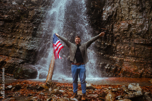 man with usa flag waterfall on background