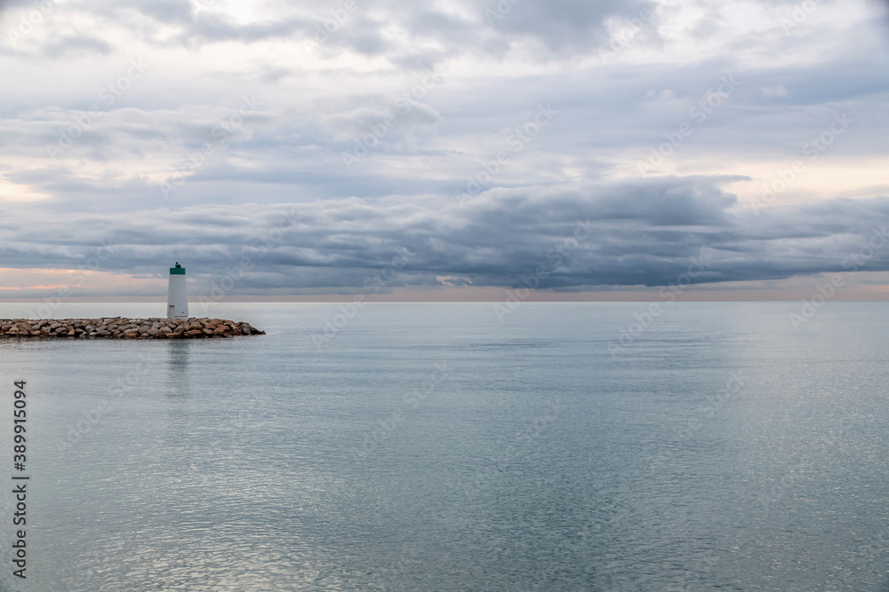 Lever de soleil sur la mer près du phare du port de Villeneuve Loubet sur la Côte d'Azur Lever de soleil sur la mer près du phare du port de Villeneuve Loubet sur la Côte d'Azur