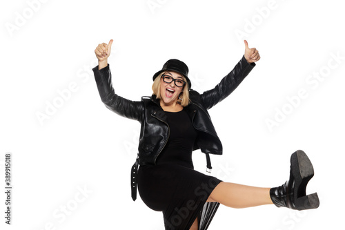 Rockstar. Beautiful young blonde woman in total black attire, outfit and eyewear isolated on white studio background. Magazine style, fashion, beauty concept. Fashionable posing. Copyspace for ad.