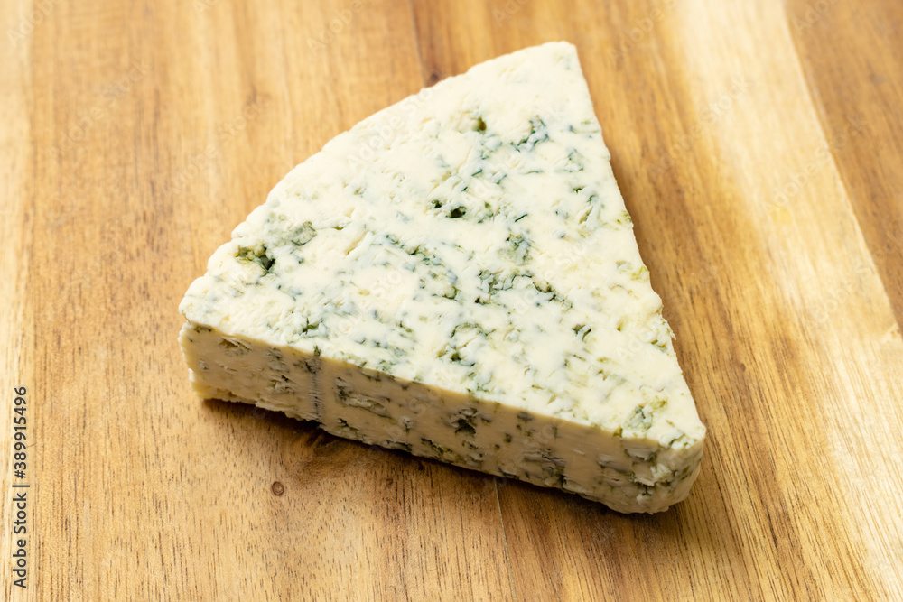 Blue cheese on a wooden background.