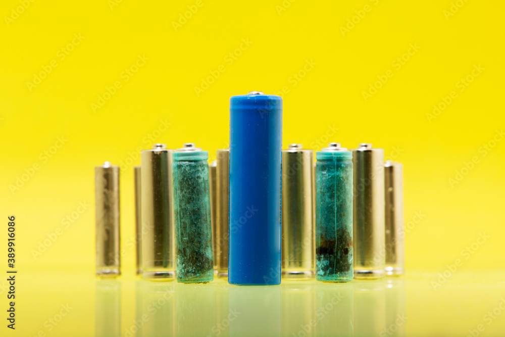 Fototapeta premium Ecology recycling concept, nature energy, many different types, used battery, rechargeable accumulator, alkaline batteries on yellow background.