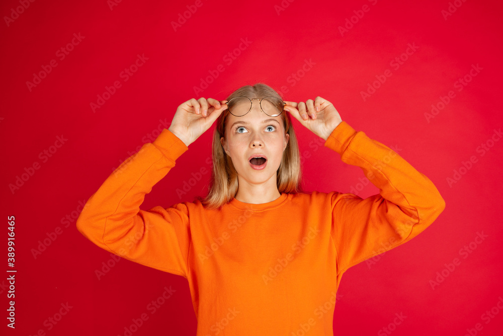 Shocked. Portrait of young caucasian woman isolated on red studio background with copyspace. Beautiful female model. Concept of human emotions, facial expression, sales, advertising, youth. Shocked. Portrait of young caucasian woman isolated on red studio background with copyspace. Beautiful female model. Concept of human emotions, facial expression, sales, advertising, youth.