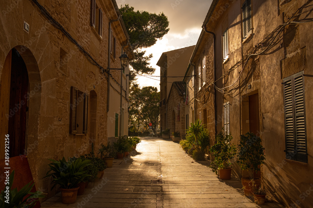 empty street in alcudia at sunset, a traditional old spanish town with ...