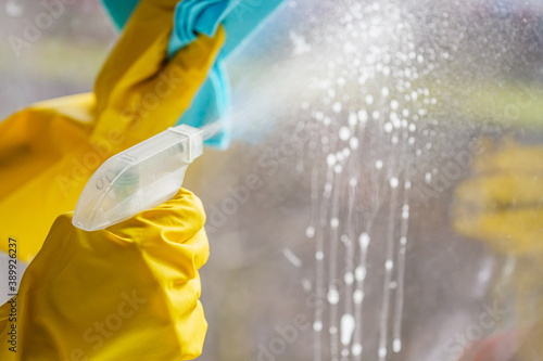 young woman housewife washes a dirty window photo