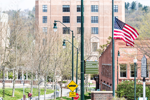 Asheville, USA - April 19, 2018: Buildings, courthouse and green Pack Square Park in North Carolina NC famous town, city in the mountains, sign, flag
