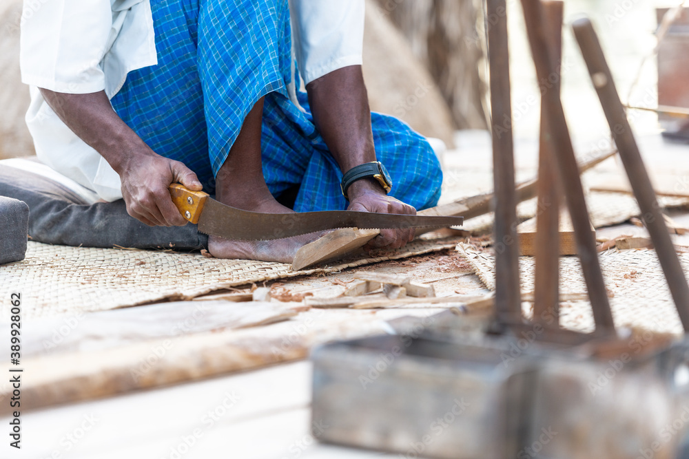 man building a traditional boat on in the UAE, isolated photography a carpenters hand and tools with focus on the hand man building a traditional boat on in the UAE, isolated photography a carpenters hand and tools with focus on the hand