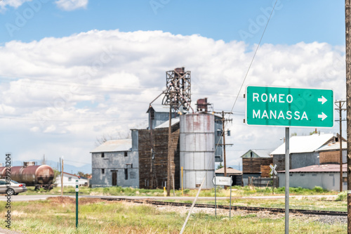 Romeo, USA - June 20, 2019: Highway 285 in Colorado with old vintage town industrial building and sign for Romeo and Manassa photo