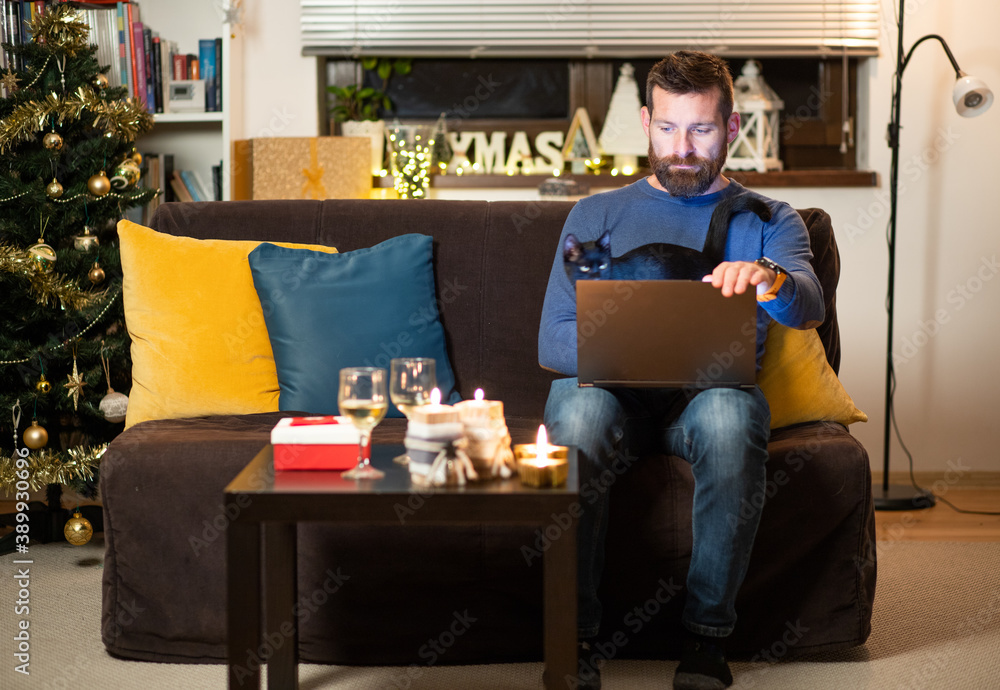 Obraz premium man with cat celebrating Christmas at home social distancing