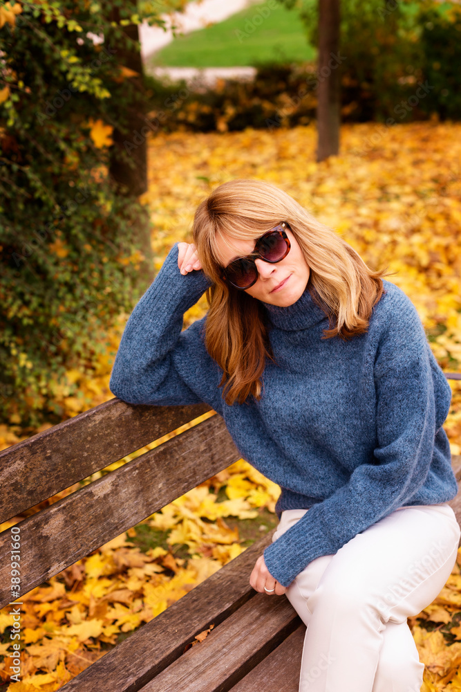 Woman sitting on the bench outdoor in the park Woman sitting on the bench outdoor in the park