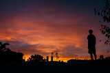 Dramatic sunset in Minorca, full of warm colors, with buildings and a man silhouette, Balearic Islands, Spain