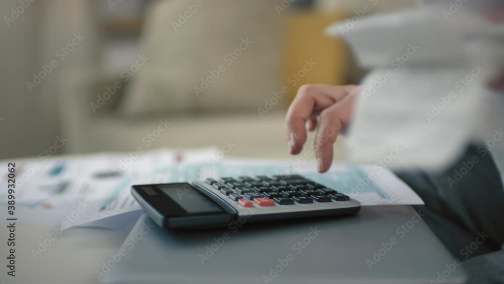 Closeup of unrecognizable female hands counting bills and taxes on calculator analyzing incomes and expenses planning budget Closeup of unrecognizable female hands counting bills and taxes on calculator analyzing incomes and expenses planning budget