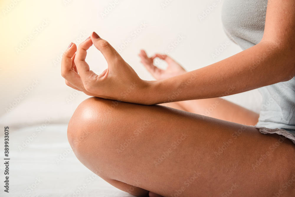 woman practicing yoga at home to be at peace. Health and wellness concept. Hands in yoga position