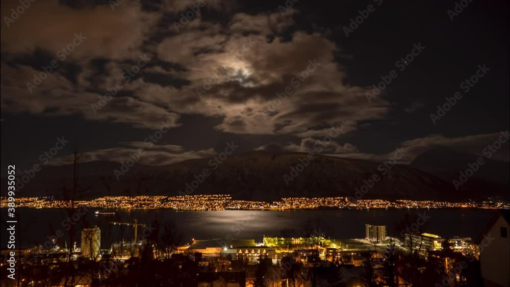 Full moon time lapse over small town by the sea with a ship passing, static Full moon time lapse over small town by the sea with a ship passing, static