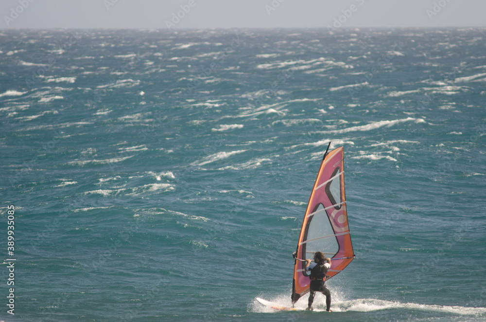 Windsurfer sailing in the coast of Arinaga. Aguimes. Gran Canaria. Canary Islands. Spain. Windsurfer sailing in the coast of Arinaga. Aguimes. Gran Canaria. Canary Islands. Spain.