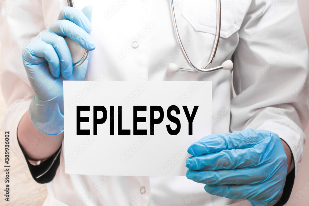 The doctor's blue - gloved hands show the word EPILEPSY - . a gloved hand on a white background. Medical concept. the medicine The doctor's blue - gloved hands show the word EPILEPSY - . a gloved hand on a white background. Medical concept. the medicine