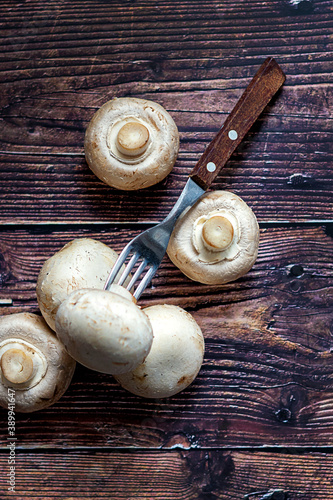 Fresh Mushrooms on wooden background with fork