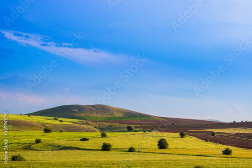 Landscape of the agricultural fields at sunset. Farming background photo. Copy space. Hills on the background. 
