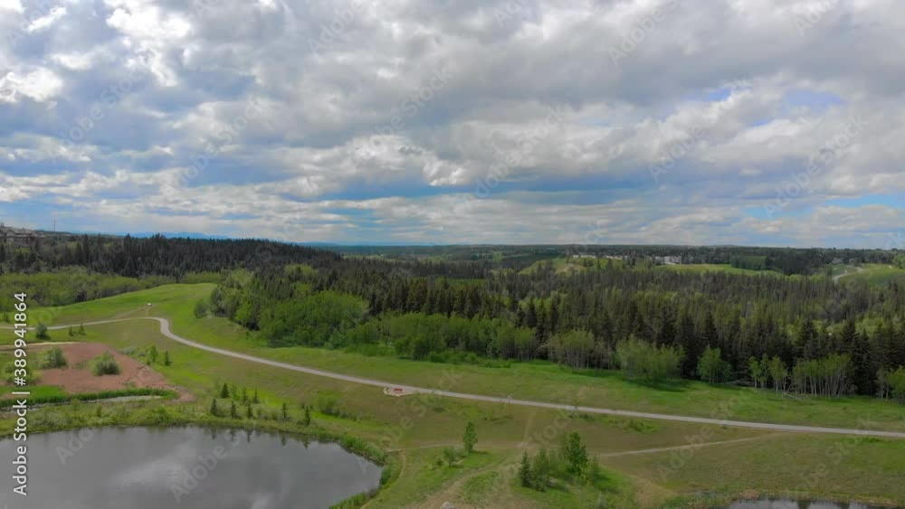 Orbiting aerial view over a park with ponds, trees and walking paths in Summer. Orbiting aerial view over a park with ponds, trees and walking paths in Summer.