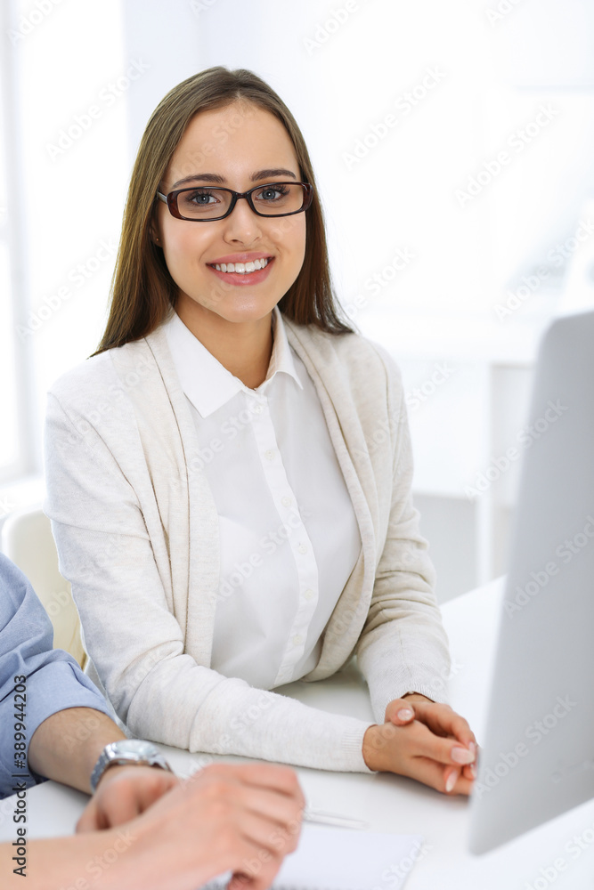 Fototapeta premium Business woman and man sitting and working with computer in office. Colleagues discussing something at meeting. Corporate teamwork and partnership concepts