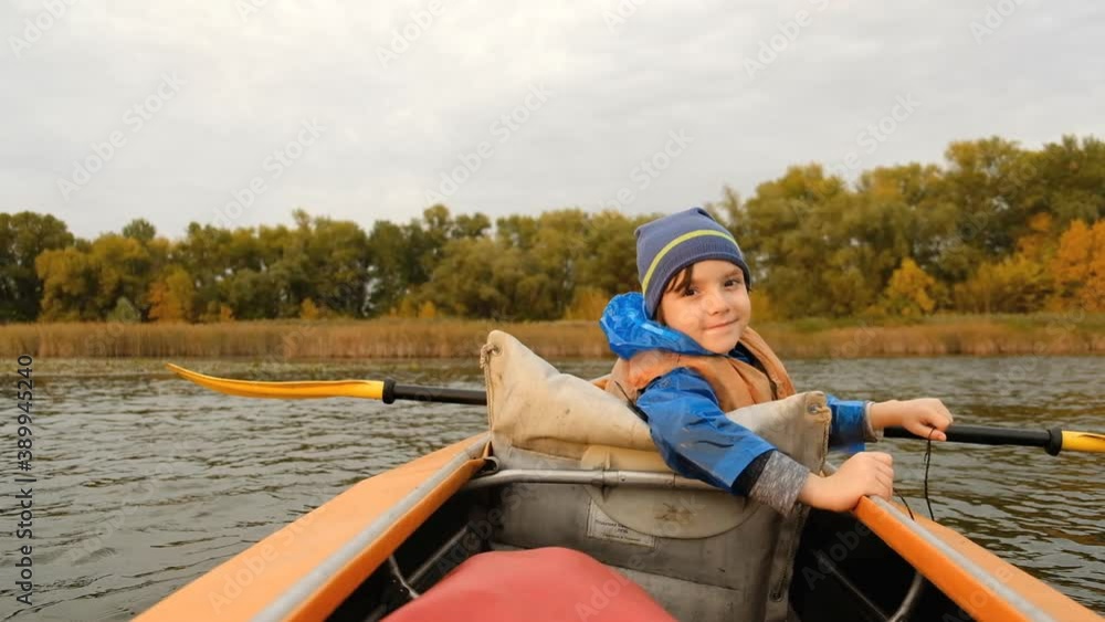 Evening kayak trip along the river in autumn. The active lifestyle of the child in the family. Evening kayak trip along the river in autumn. The active lifestyle of the child in the family.
