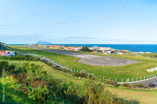 Fototapeta Naklejka Na Ścianę i Meble -  Azores, island of Graciosa, view at the airport of Santa Cruz da Graciosa. th runway is near houses and church.