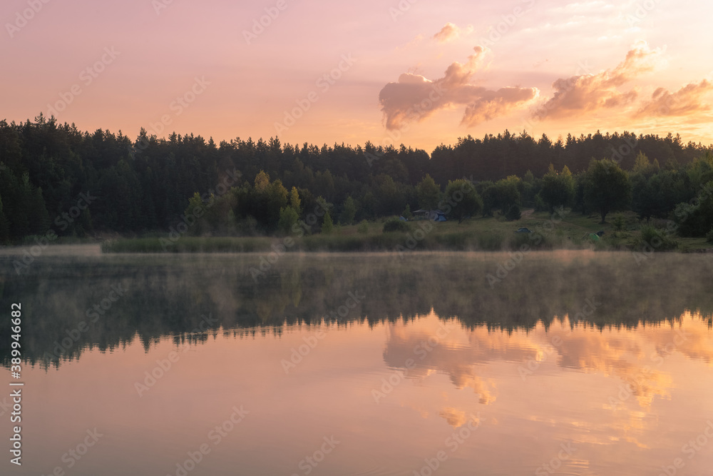 Beautiful pink sunrise over the surface of the lake.. Reflections of clouds on the water. Beautiful pink sunrise over the surface of the lake.. Reflections of clouds on the water.