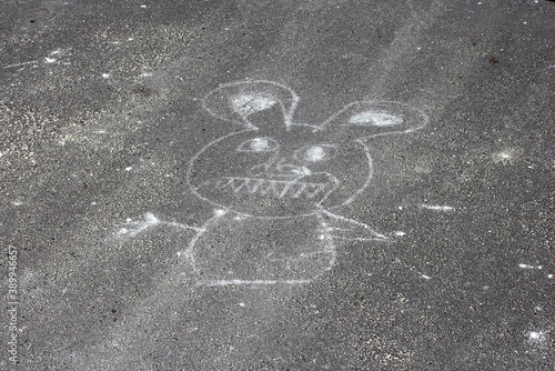 An angry rabbit is drawn in chalk on the asphalt