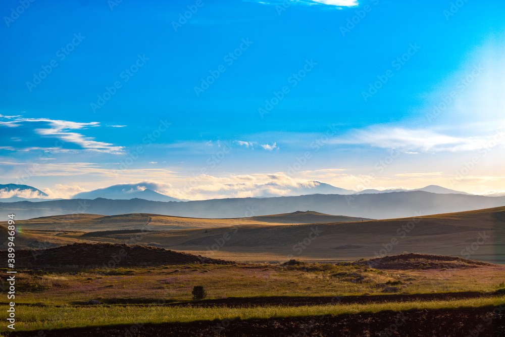 Landscape of the hills and cloudy sky. agricultural fields and foggy hills on the background. sunrise.