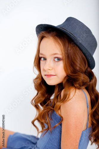 dressed in a light blue dress on spaghetti straps cute little girl on a white background