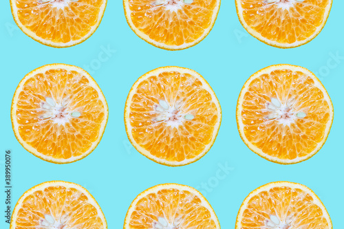 Colorful pattern of cutted orange fruits  isolated on background of cyan or aqua menthe color.