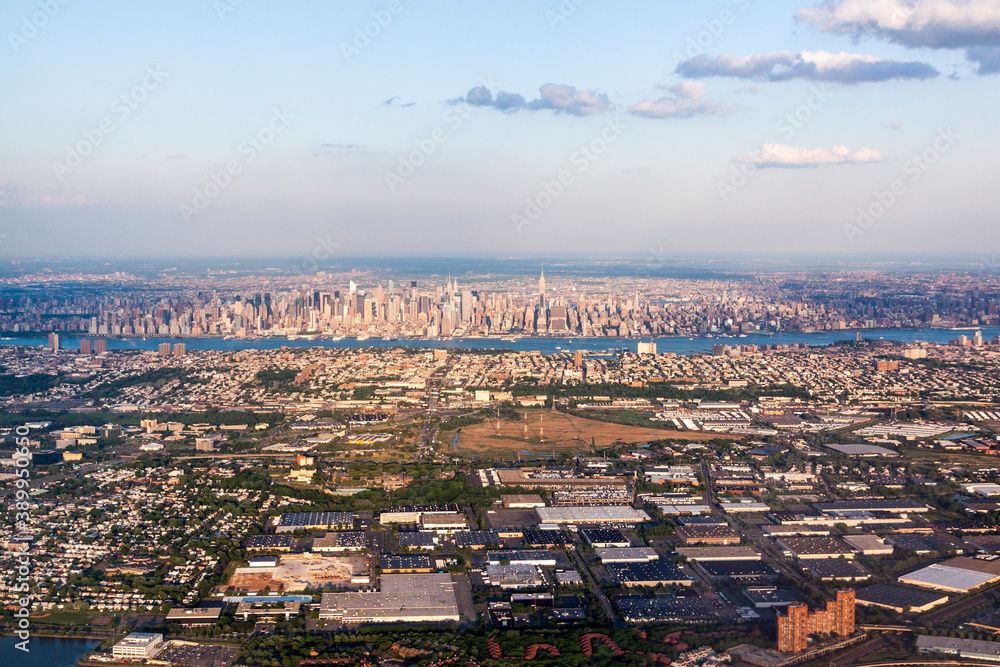 Aerial view of New York City and Hudson River with industrial area of New Jersey in the foreground in the afternoon.