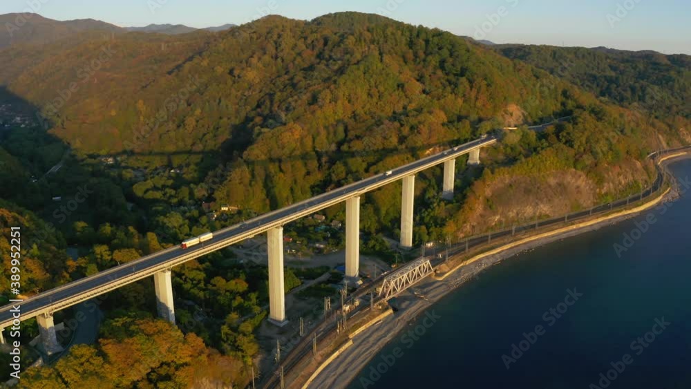 Beautiful large bridge for motorway across sea, aerial view of drone slide turn, beautiful design of the automotive bridge in sea. Travel. Flying Over Bridge as Cars Pass. Sochi, Russia Beautiful large bridge for motorway across sea, aerial view of drone slide turn, beautiful design of the automotive bridge in sea. Travel. Flying Over Bridge as Cars Pass. Sochi, Russia