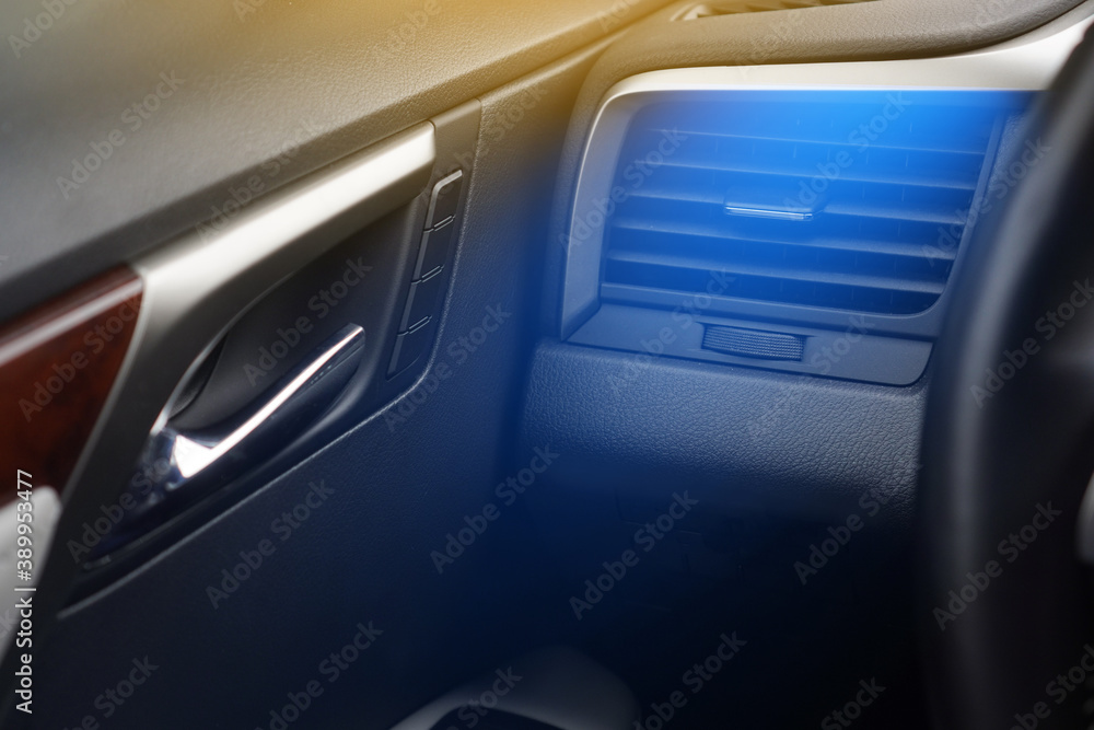 Car air conditioning concept. Cold air from the vent panel grille of a modern car.