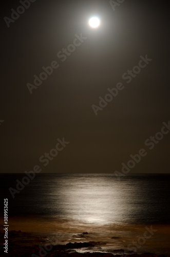 Seascape at night and moon reflected in the water. Arinaga. Aguimes. Gran Canaria. Canary Islands. Spain.