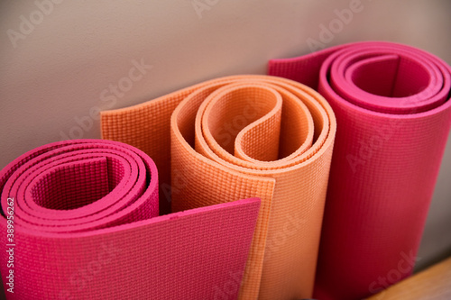 Rolled up storage colored mats for yoga fitness and sports. photo