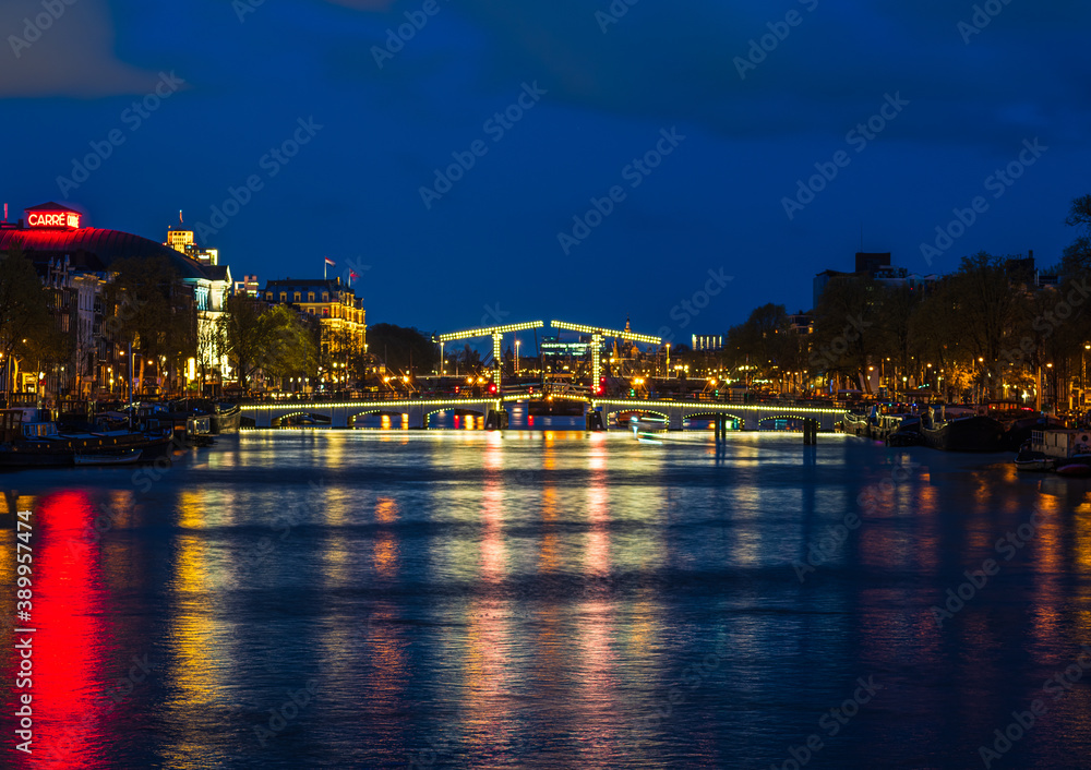 Puente luminioso en un canal de Amsterdam al anochecer