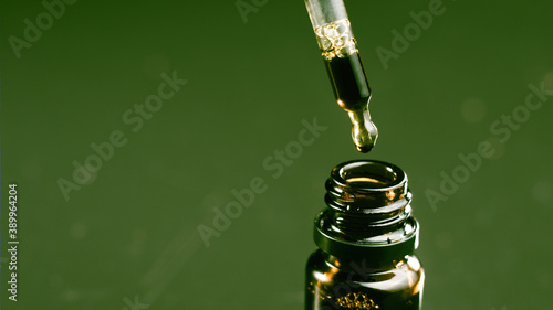 Hand holding pipette of cannabis oil. CBD As Alternative Medicine.