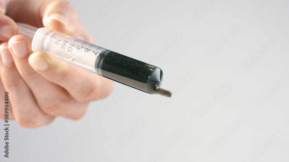 CBD Paste made of Hemp cannabidiol. Hand holding Cannabis oil extract in syringe. CBD Paste made of Hemp cannabidiol. Hand holding Cannabis oil extract in syringe.