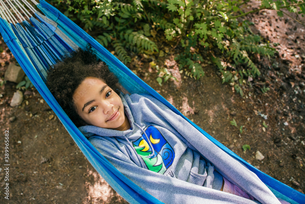 Happy, smiling girl relaxing in hammock in forest campground Happy, smiling girl relaxing in hammock in forest campground