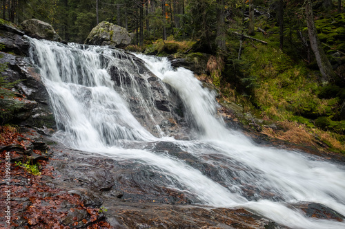 big waterfall cascades in the forest  water among the rocks  power of nature in bohemian forest