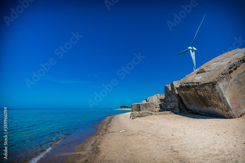 Old war fort ruins on the beach with a wind turbine. Liepaja, Latvia