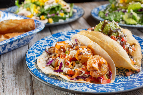A view of a Tex Mex meal layout, in a restaurant or kitchen setting, featuring shrimp tacos.