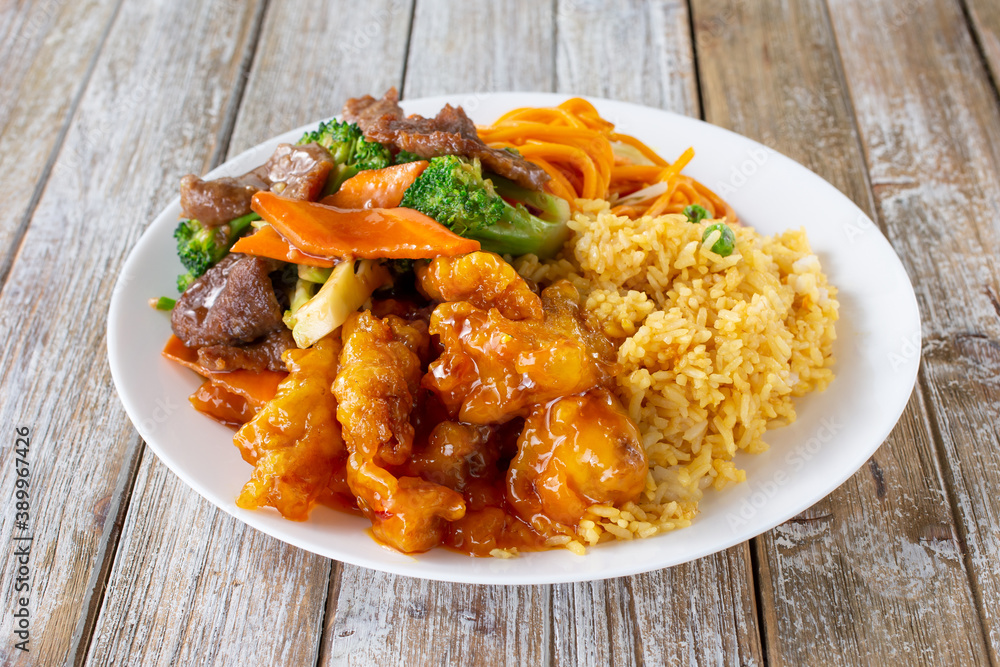 A view of a Chinese fast food 2 item combo plate, featuring orange chicken and beef broccoli. A view of a Chinese fast food 2 item combo plate, featuring orange chicken and beef broccoli.