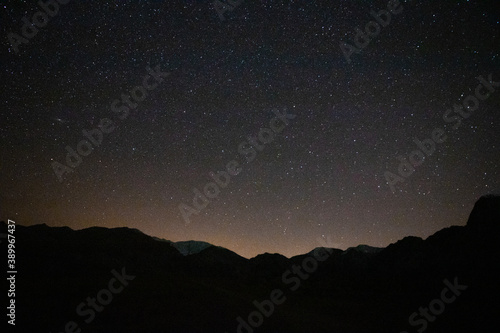 starry night sky with a little city lights pollution on the horizon © senerdagasan