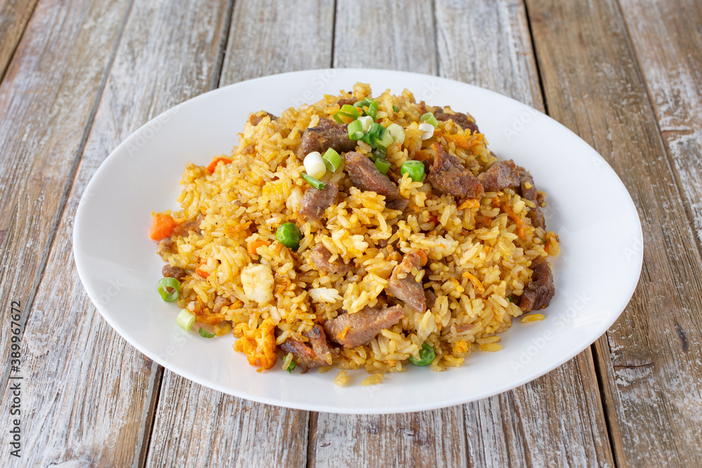 A view of a plate of beef fried rice.