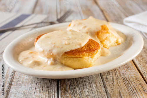 A view of a plate of biscuits and gravy, in a restaurant or kitchen setting.