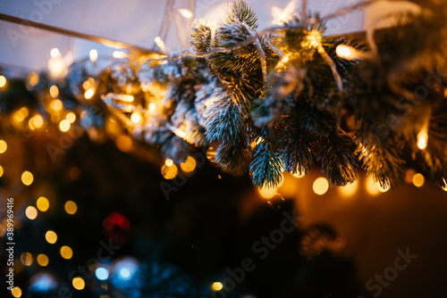 New Year 2021 interior with candles  bulbs and bokeh. Room decorated to christmas celebration. Christmas tree with presents