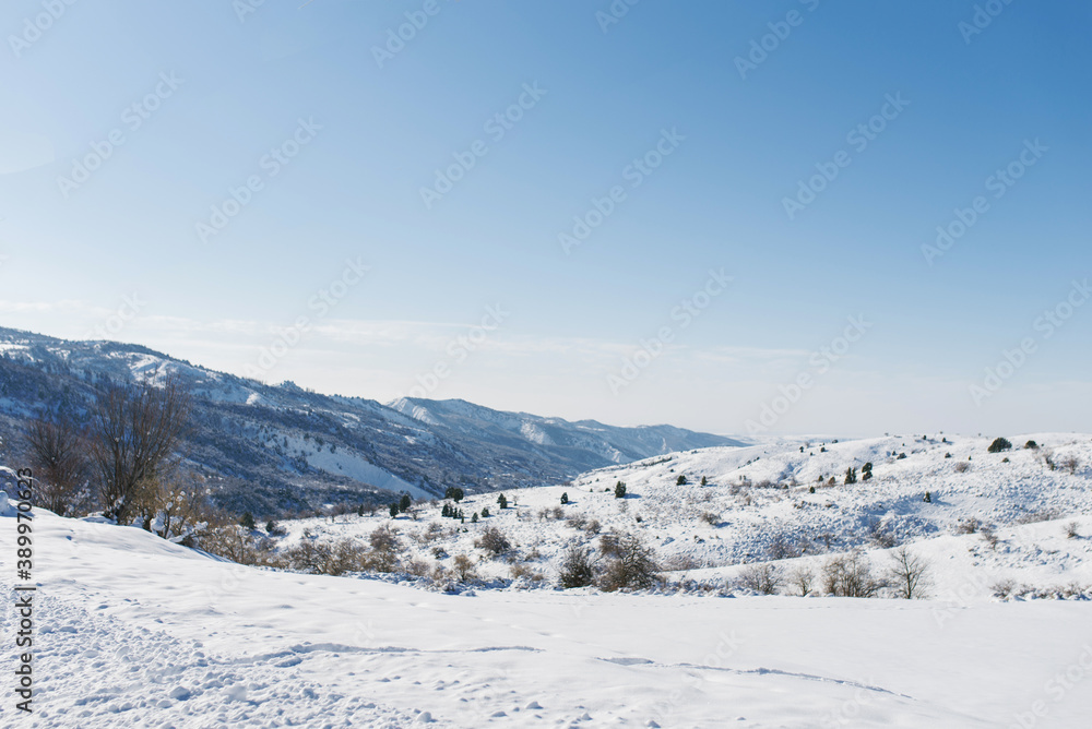 First snow in the mountains of Uzbekistan. Winter mountain landscape in clear Sunny weather. Chimgan