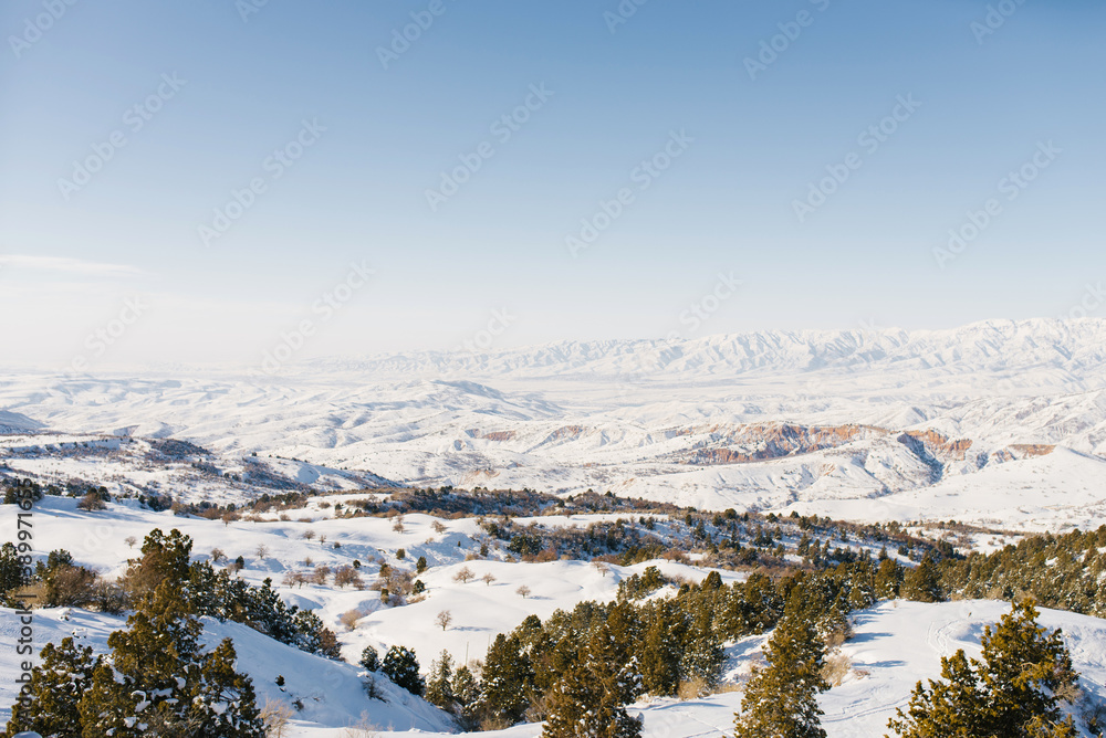 Panorama of snowy slopes covered with snow in Sunny weather. Winter landscape in the mountains of the Beldersay ski resort