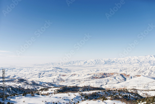 Panorama of the Tien Shan mountains covered with snow in Sunny weather. Winter landscape in the mountains of the Beldersay ski resort